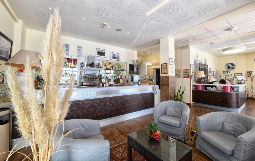 un hall d'entrée avec deux chaises et un bar dans l'établissement Hotel Ancore, à Senigallia