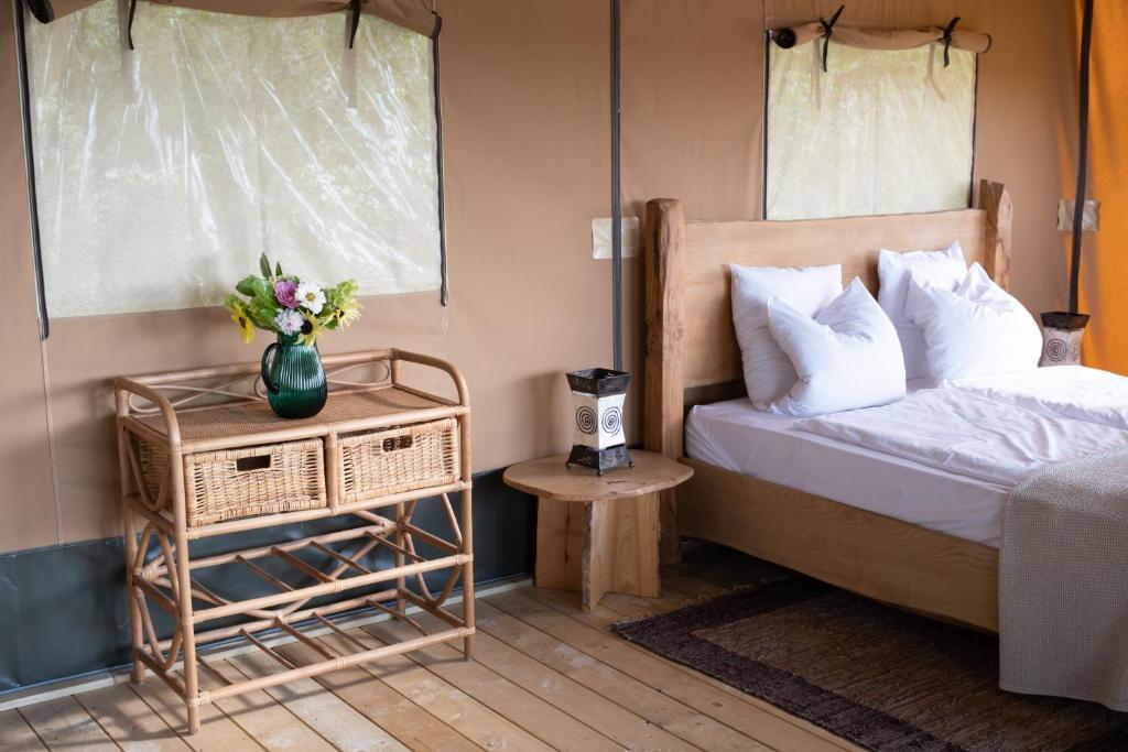 une chambre avec un lit et un vase de fleurs sur une table dans l'établissement Le Camp, à Varen