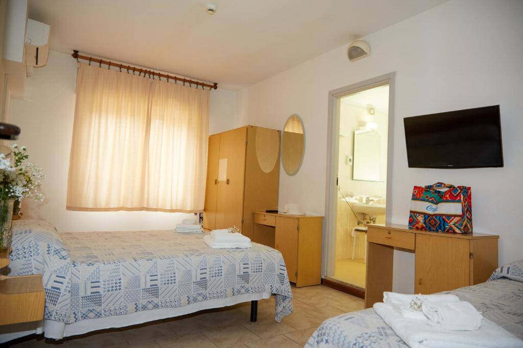 une chambre d'hôtel avec deux lits et un miroir dans l'établissement Hotel ITALIACERVIA, à Cervia