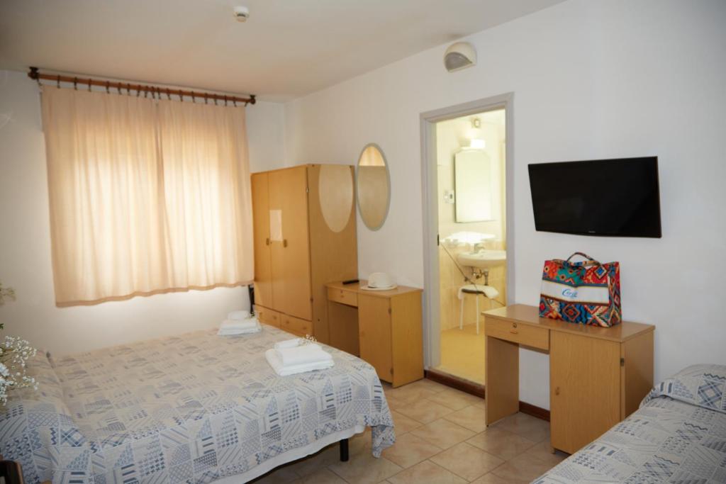 une chambre avec un lit, un lavabo et un miroir dans l'établissement Hotel ITALIACERVIA, à Cervia