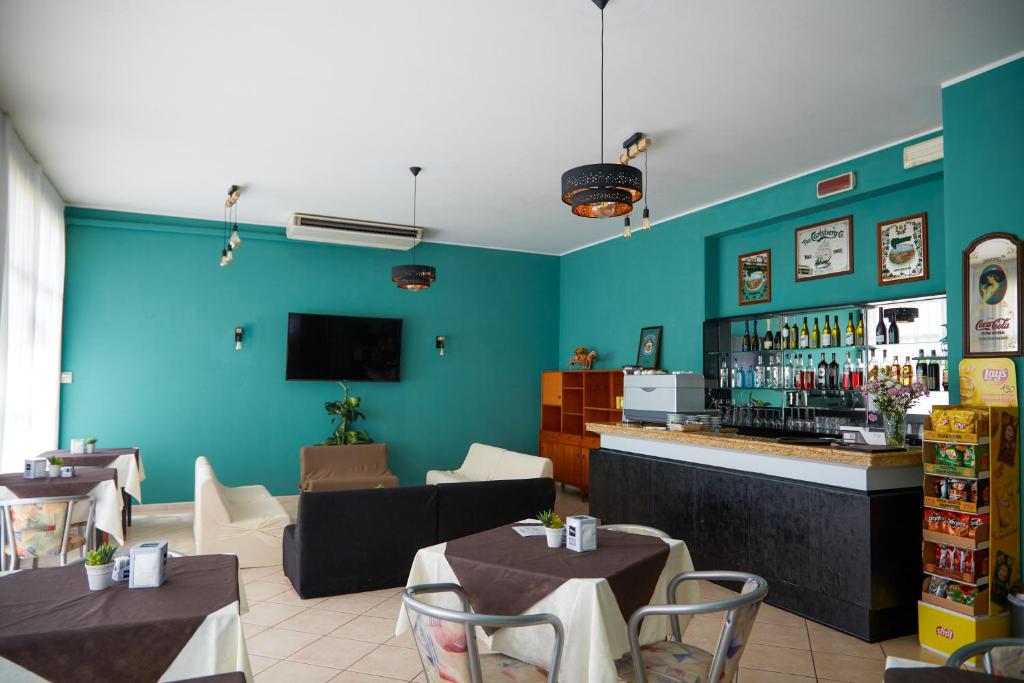 un restaurant avec un bar aux murs et tables bleus dans l'établissement Hotel ITALIACERVIA, à Cervia