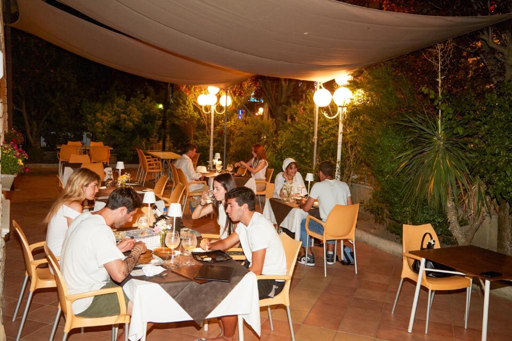 un groupe de personnes assises à des tables dans un restaurant dans l'établissement Hotel ITALIACERVIA, à Cervia
