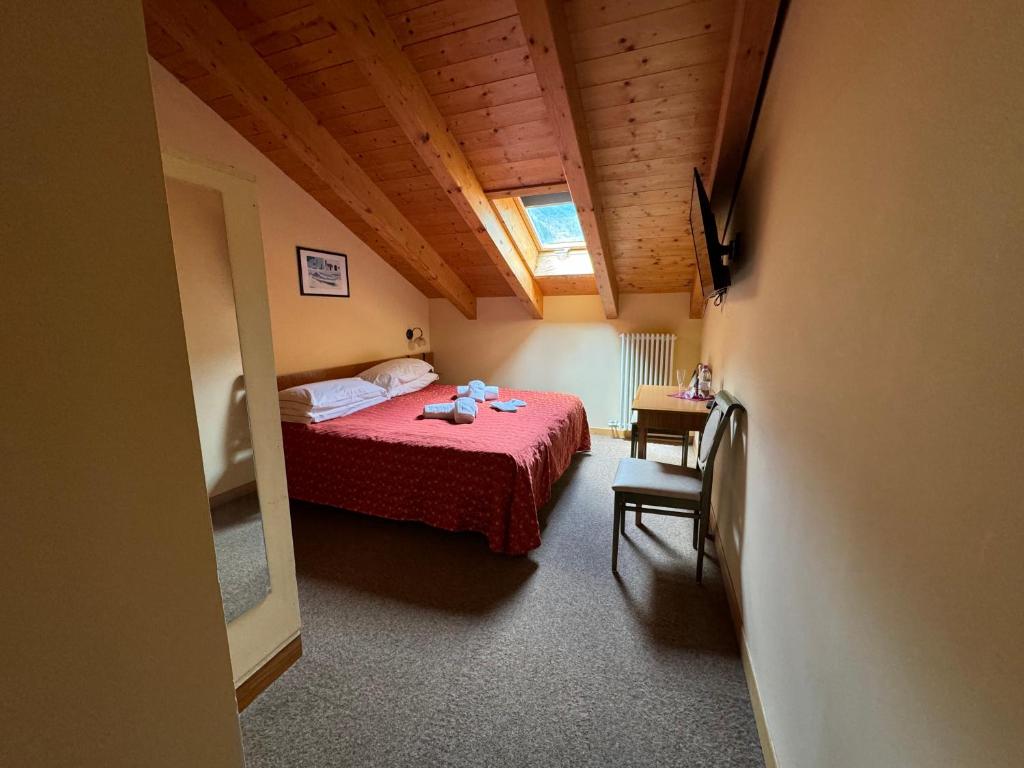 une chambre avec un lit avec un couvre-lit rouge dans l'établissement Garden Hotel Bellariva, à Molveno
