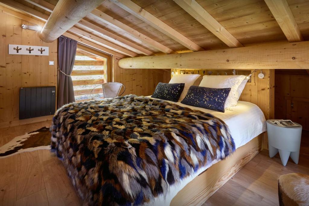 une chambre avec un lit dans une cabane en rondins dans l'établissement Le Grand Capricia - OVO Network, à La Clusaz