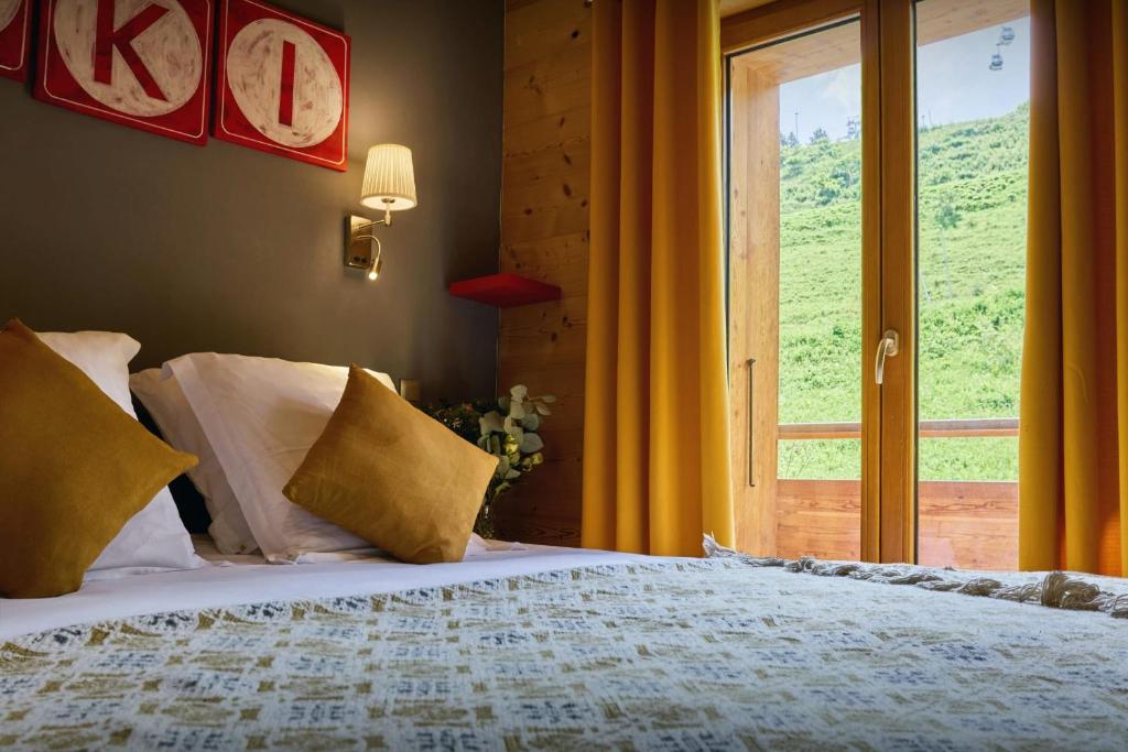 une chambre avec un grand lit et une fenêtre dans l'établissement Le Grand Capricia - OVO Network, à La Clusaz 15 autres photos
