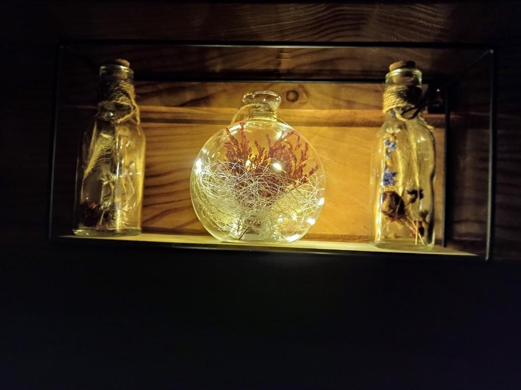 trois bouteilles en verre assises sur une étagère dans l'établissement Roulotte de la Ferme Les Chenevières, à Villers-devant-Mouzon