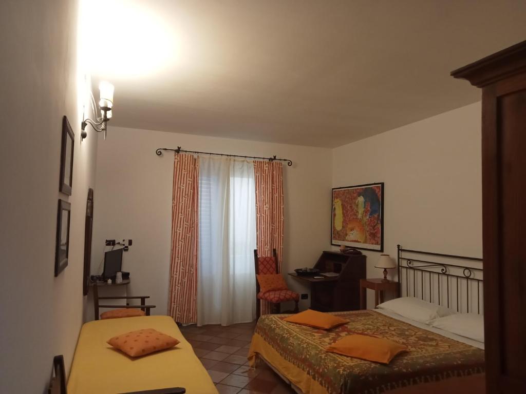 une chambre avec deux lits et un bureau et une fenêtre dans l'établissement Albergo Boutique Casajanca, à Canneto