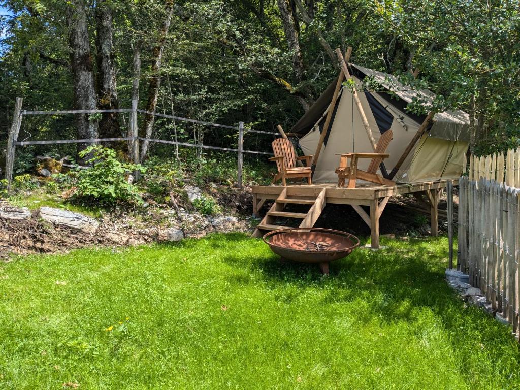 une tente dans une cour avec 2 chaises et un panier dans l'établissement The Mountain Nest, à La Pirraz