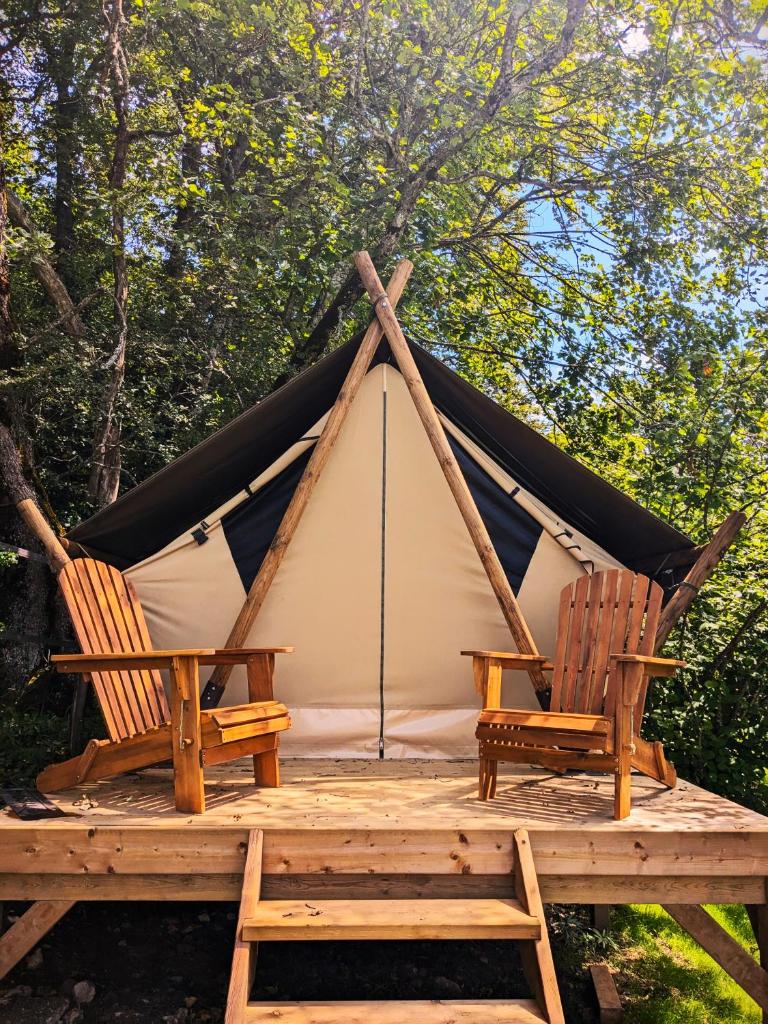 - deux chaises sur une terrasse en bois avec une tente dans l'établissement The Mountain Nest, à La Pirraz