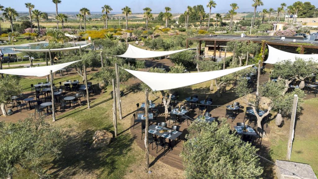 une vue aérienne d'un restaurant avec des tables et des tentes blanches dans l'établissement Mangia's Selinunte Resort, à Marinella di Selinunte