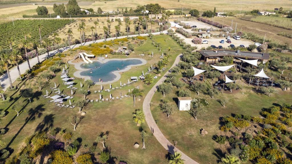 - une vue aérienne sur un parc avec un lac dans l'établissement Mangia's Selinunte Resort, à Marinella di Selinunte