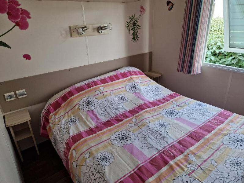 une chambre avec un lit avec une couette dessus dans l'établissement Mobil home le castellas, à Mèze