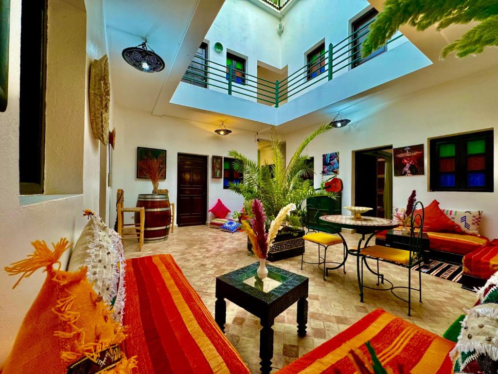 un salon avec un canapé, une table et des chaises dans l'établissement Riad Iklil, à Marrakech