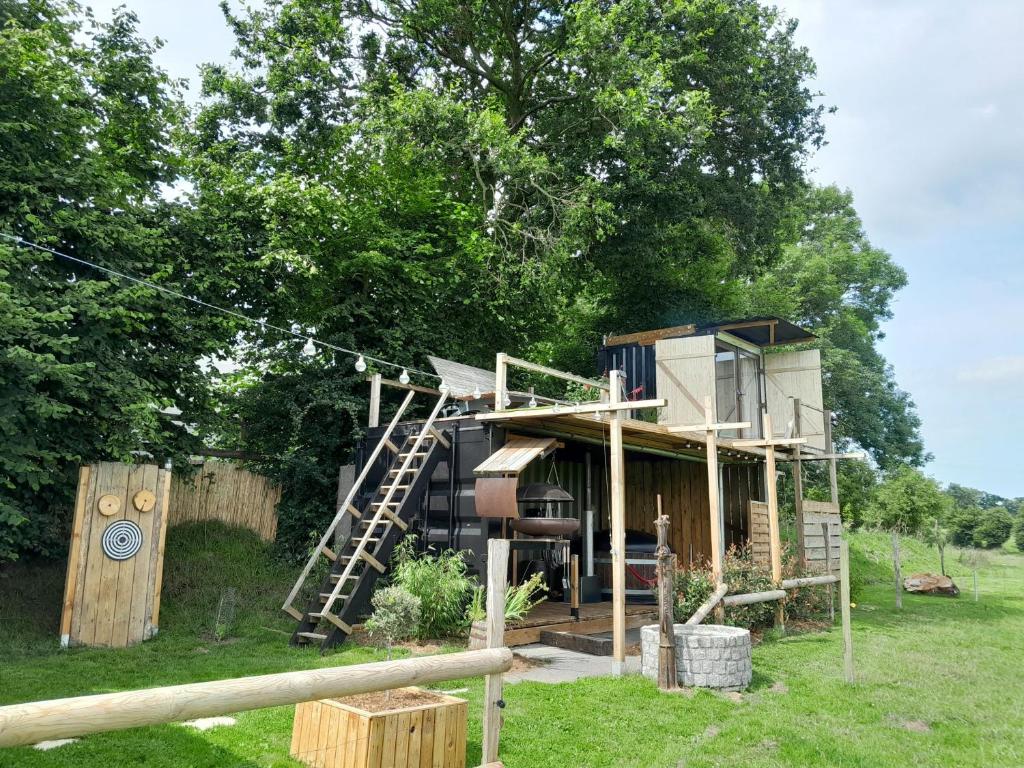 une cabane dans les arbres au milieu d'un champ dans l'établissement cabane amazonia, à Litteau
