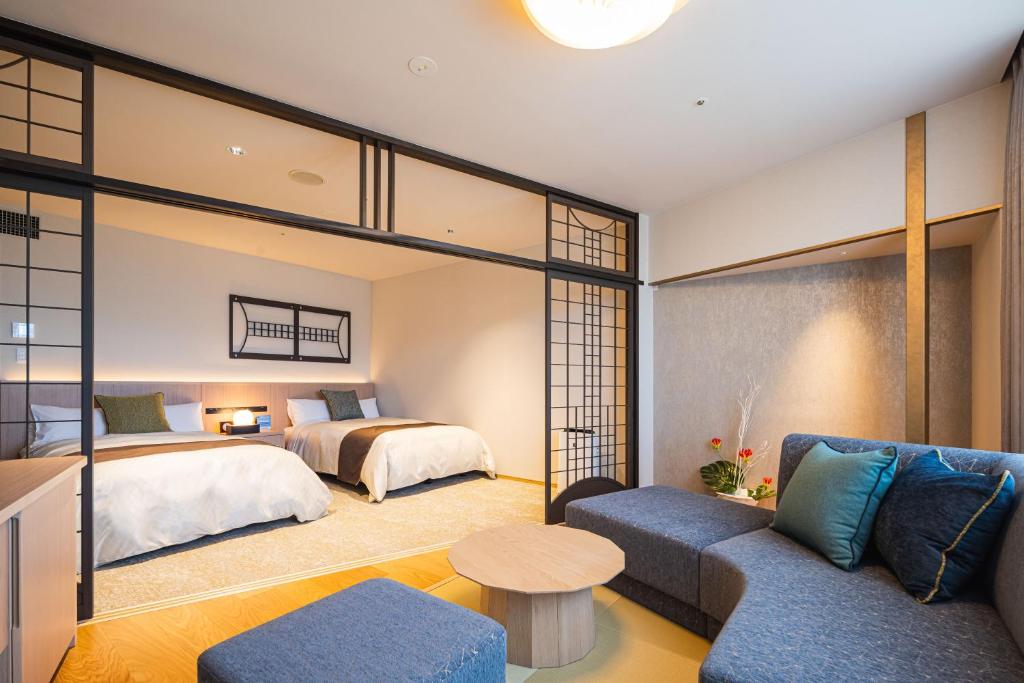 - une chambre d'hôtel avec un lit et un canapé dans l'établissement Dogo Kan, à Matsuyama