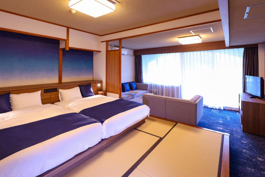 une chambre d'hôtel avec un grand lit et une télévision dans l'établissement Ooedo Onsen Monogatari Premium Kinugawa Kanko Hotel, à Nikkō