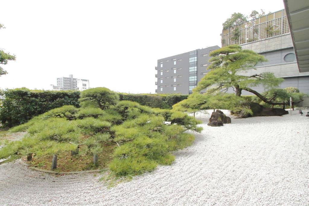 un groupe d'arbres sur une plage près d'un bâtiment dans l'établissement Dogo Kan, à Matsuyama 27 autres photos
