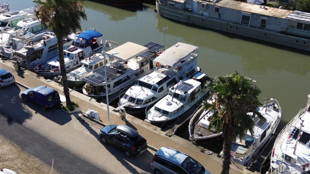 un tas de bateaux garés dans un port de plaisance avec des voitures dans l'établissement BATEAU - Jolie pénichette sur région touristique., à Bellegarde