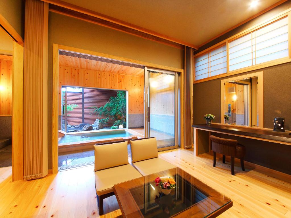 un salon avec un canapé et une table en verre dans l'établissement 匠晴の宿 心庵, à Beppu