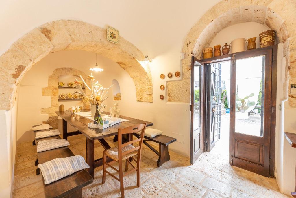 une salle à manger avec une table et une porte dans l'établissement Trulli delle Grotte, à Castellana Grotte