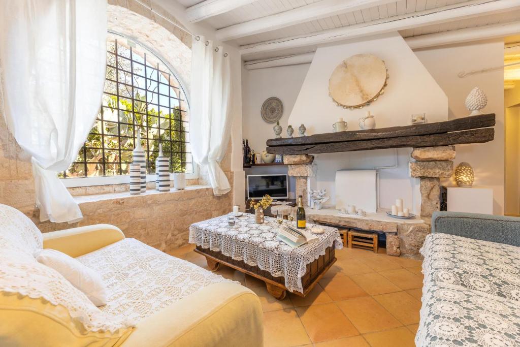 un salon avec un canapé et une cheminée dans l'établissement Trulli delle Grotte, à Castellana Grotte