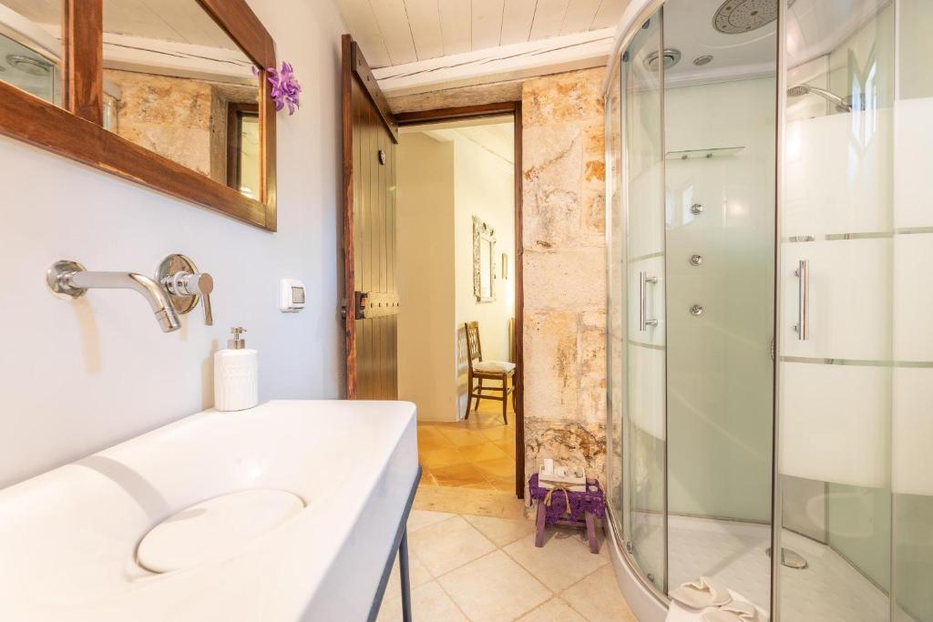 une salle de bain avec un lavabo et une douche dans l'établissement Trulli delle Grotte, à Castellana Grotte