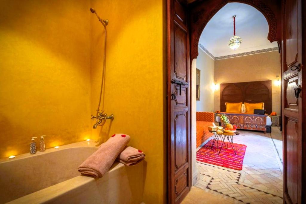 une salle de bain avec baignoire et une chambre dans l'établissement Riad Vilamoura & SPA, à Marrakech