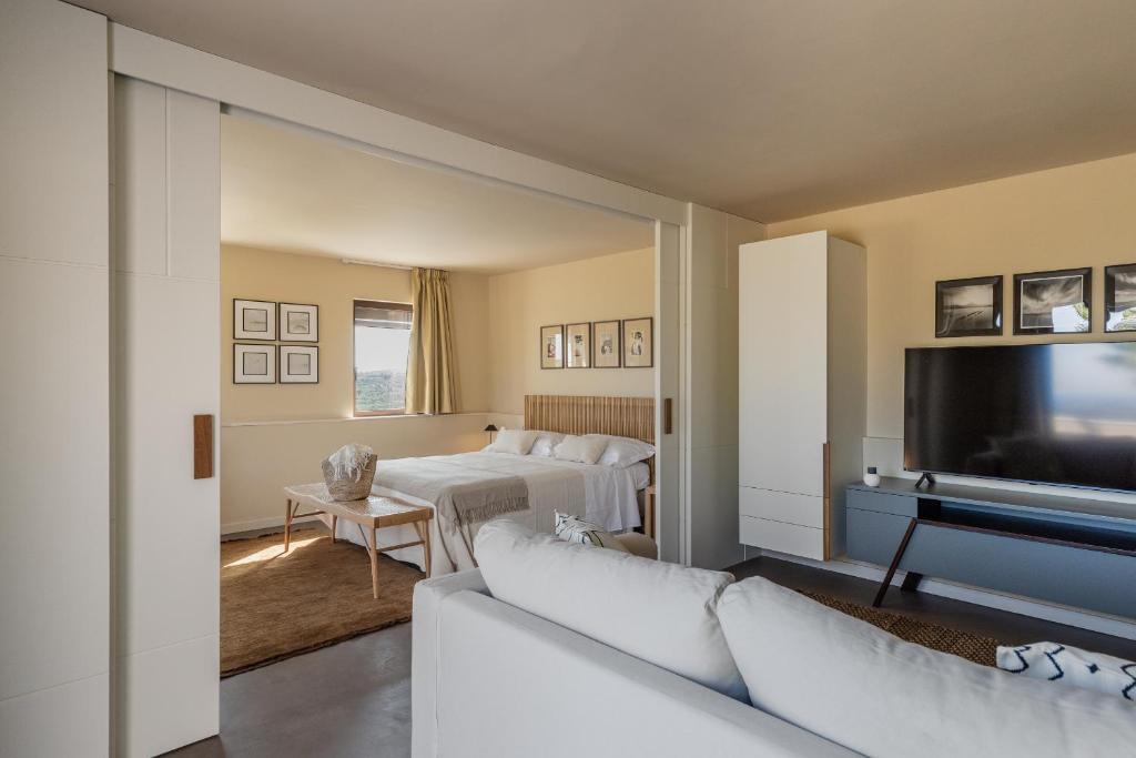 un salon avec deux lits et une télévision à écran plat dans l'établissement Altamira - Luxury Villa con piscina a Noto, à Noto