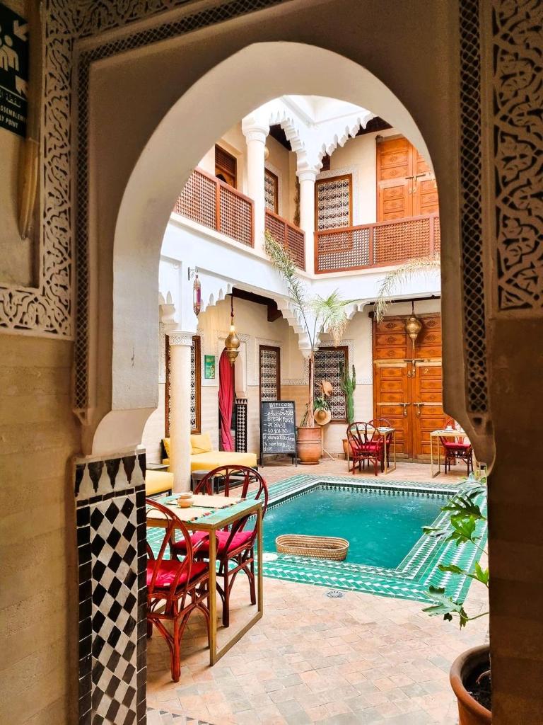 une arche menant à une piscine dans une villa dans l'établissement Riad Vilamoura & SPA, à Marrakech
