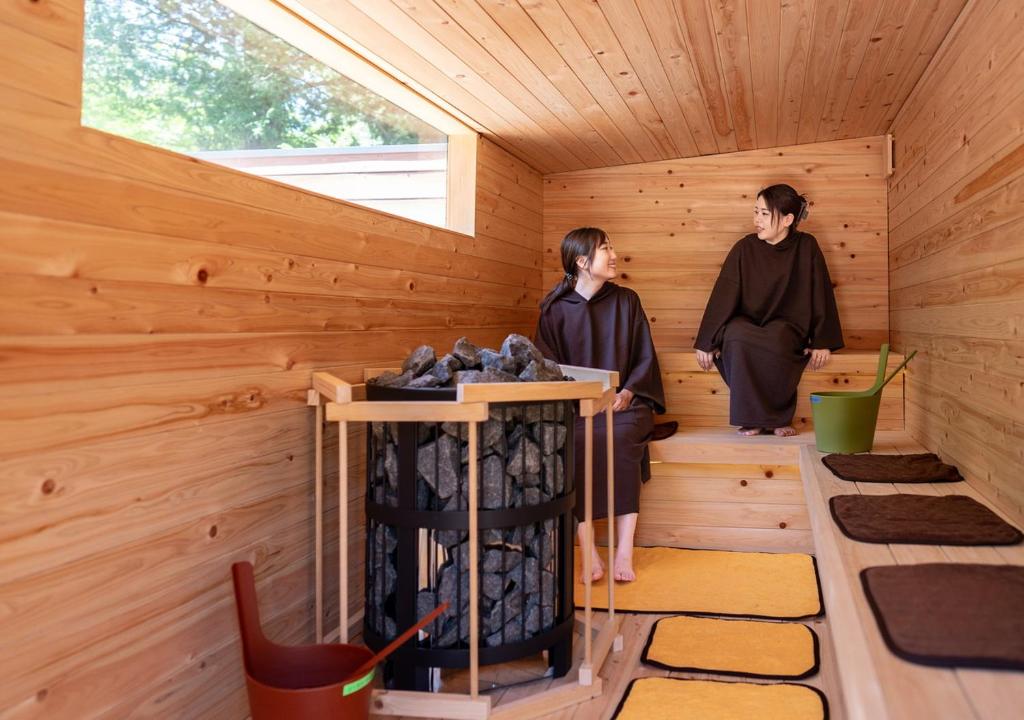 2 femmes debout dans un sauna en bois dans l'établissement Morino Hotel, à Kiso