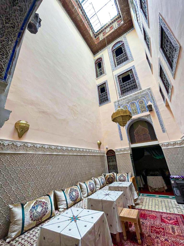 une pièce avec des tables et des chaises dans un bâtiment dans l'établissement Riad Dar Fatihi Fes, à Fès