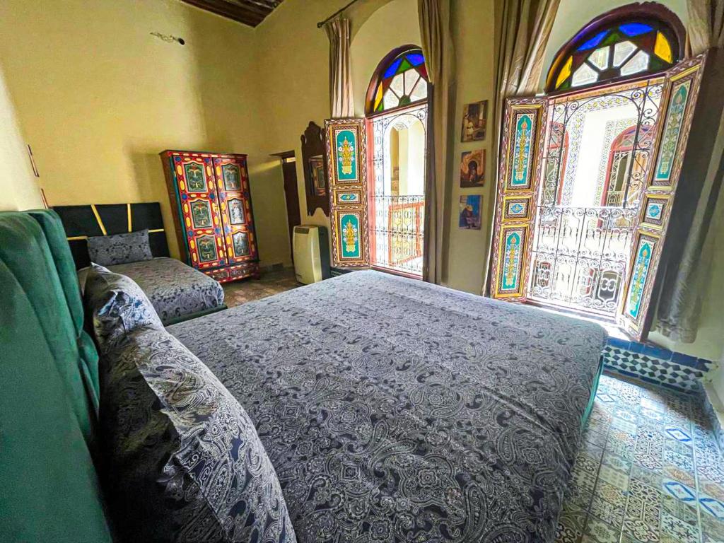 - une chambre avec 2 lits et des vitraux dans l'établissement Riad Dar Fatihi Fes, à Fès