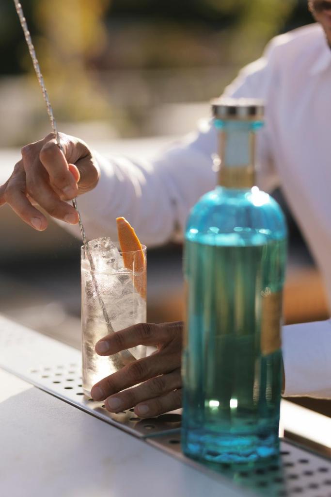 une personne tenant une boisson à côté d'une bouteille bleue dans l'établissement View Place & Spa, à Numana 129 autres photos