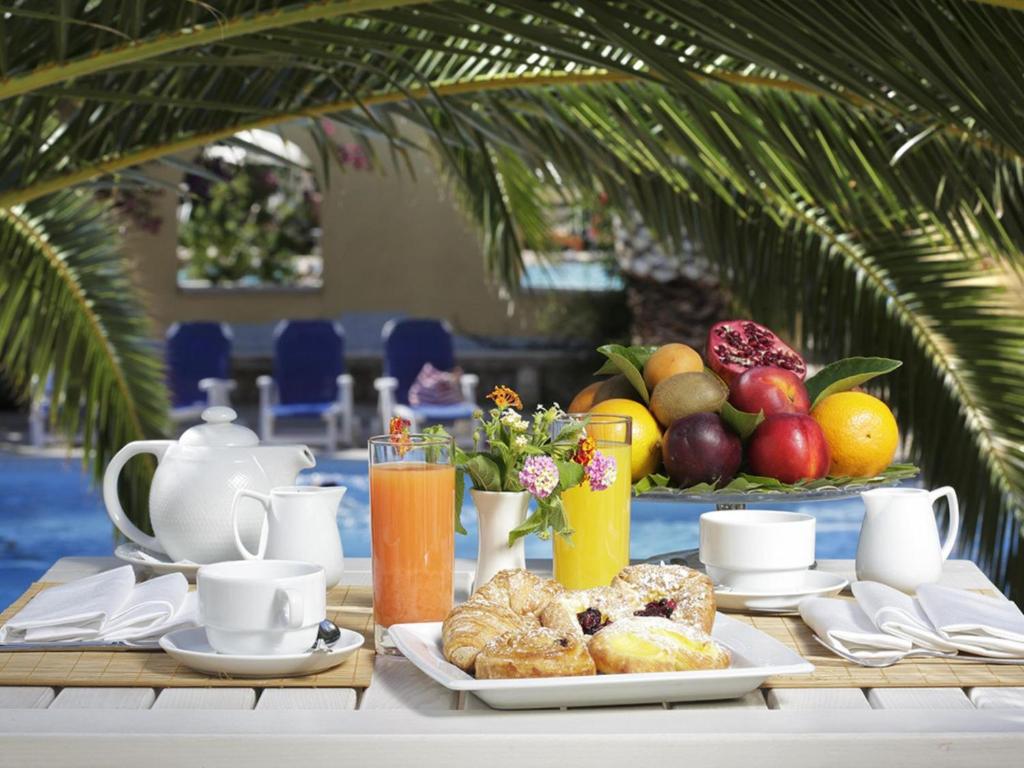 une table avec un petit-déjeuner composé de fruits et de viennoiseries dans l'établissement Hotel I Melograni, à Vieste 15 autres photos