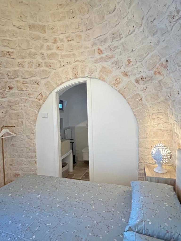 une chambre avec un mur en pierre et un lit dans l'établissement Trulli Biancopumo - private pool, à Monopoli 36 autres photos