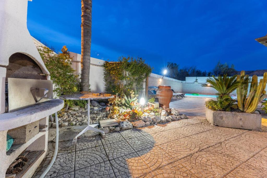 un patio avec une table, des chaises et des plantes dans l'établissement Villa Messapia, à Torre dell'Orso