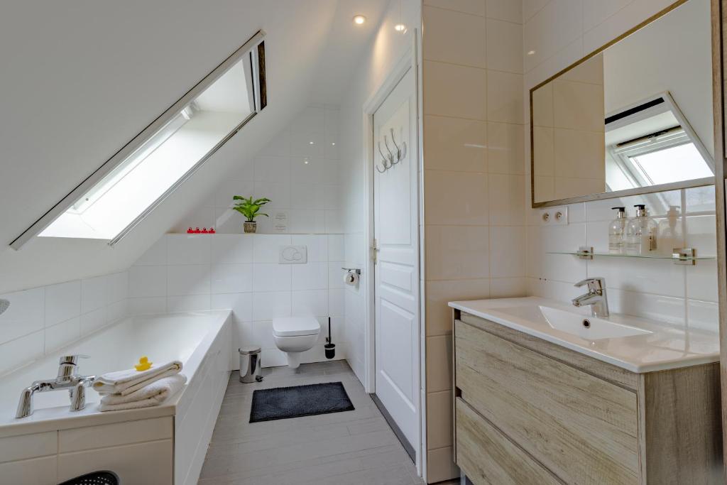 une salle de bain blanche avec un lavabo et des toilettes dans l'établissement Gîte La Mauratie, à Jayac