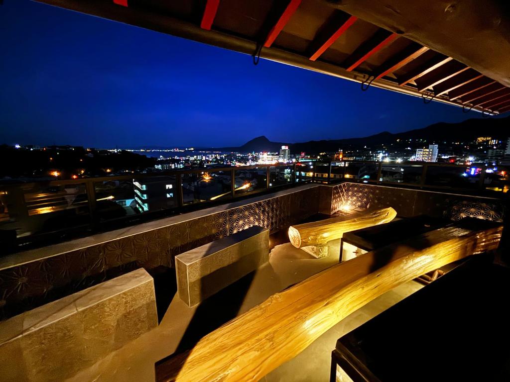 une vue d'une ville la nuit avec des bancs dans l'établissement 日本旅館 器 別府鉄輪 nihonryokan utsuwa beppukannnawa, à Beppu