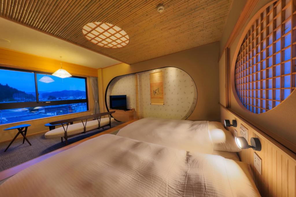 une chambre avec un grand lit et une fenêtre dans l'établissement Honjin Hiranoya Annex, à Takayama