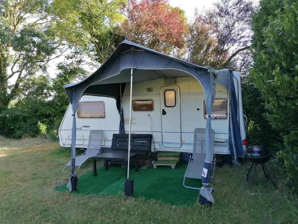 une tente blanche assise dans l'herbe dans un champ dans l'établissement Caravane des prés, à Saint-Georges-de-Didonne