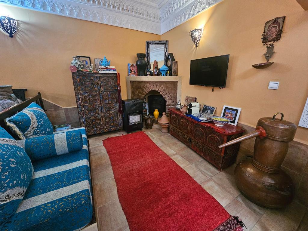 un salon avec un canapé et une cheminée dans l'établissement Riad Dar Rita, à Ouarzazate