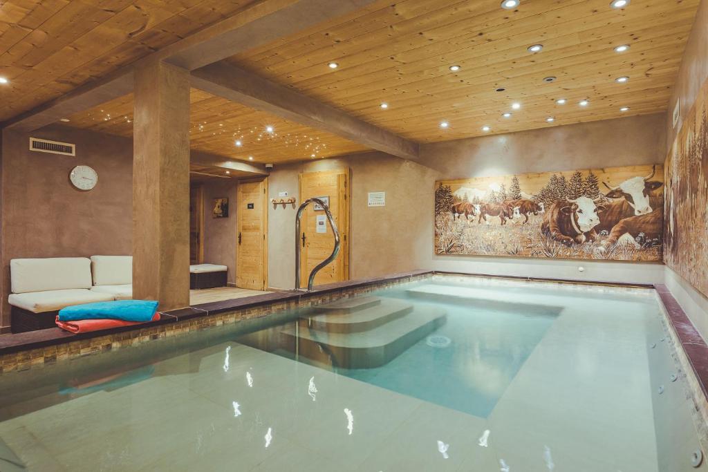 - une grande piscine dans une pièce dotée d'un plafond dans l'établissement La Clef des Champs, à Morzine