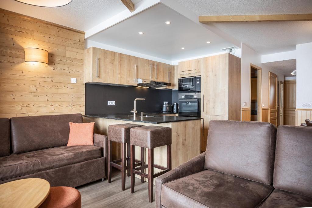 un salon avec un canapé et un bar dans l'établissement Résidence Les Balcons de Val Chavière, à Val Thorens