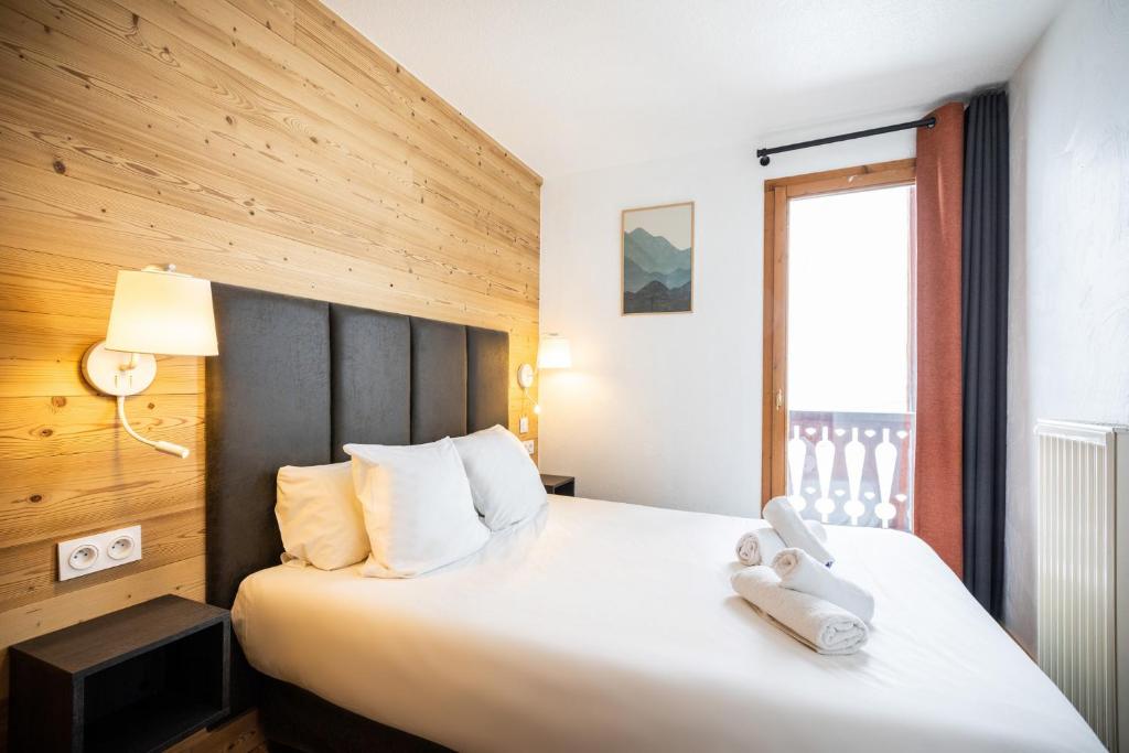une chambre avec un grand lit blanc avec une fenêtre dans l'établissement Résidence Les Balcons de Val Chavière, à Val Thorens 37 autres photos