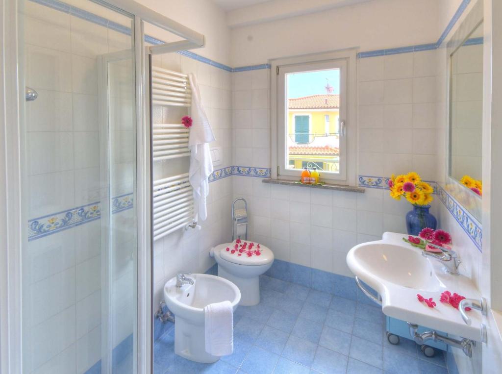 une salle de bain avec toilettes, lavabo et douche dans l'établissement Residence I Giardini Del Conero, à Porto Recanati
