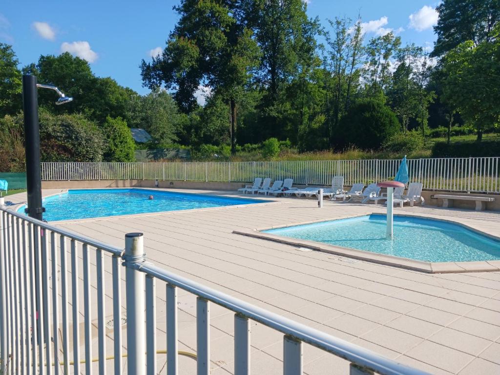 une piscine avec une terrasse et une clôture dans l'établissement Mobil'home, à Thiviers