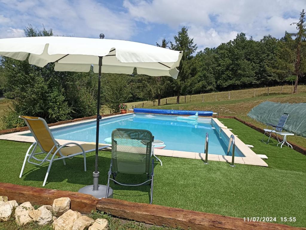 un parasol et des chaises à côté d'une piscine dans l'établissement Studio cosy en pleine nature dans maison en pierre avec piscine et wifi, à Saint-Romain-et-Saint-Clément