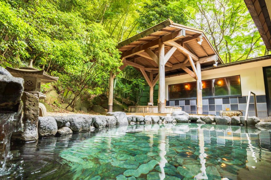 une maison avec une piscine et une pergola en bois dans l'établissement Yumoto Fujiya Hotel, à Hakone