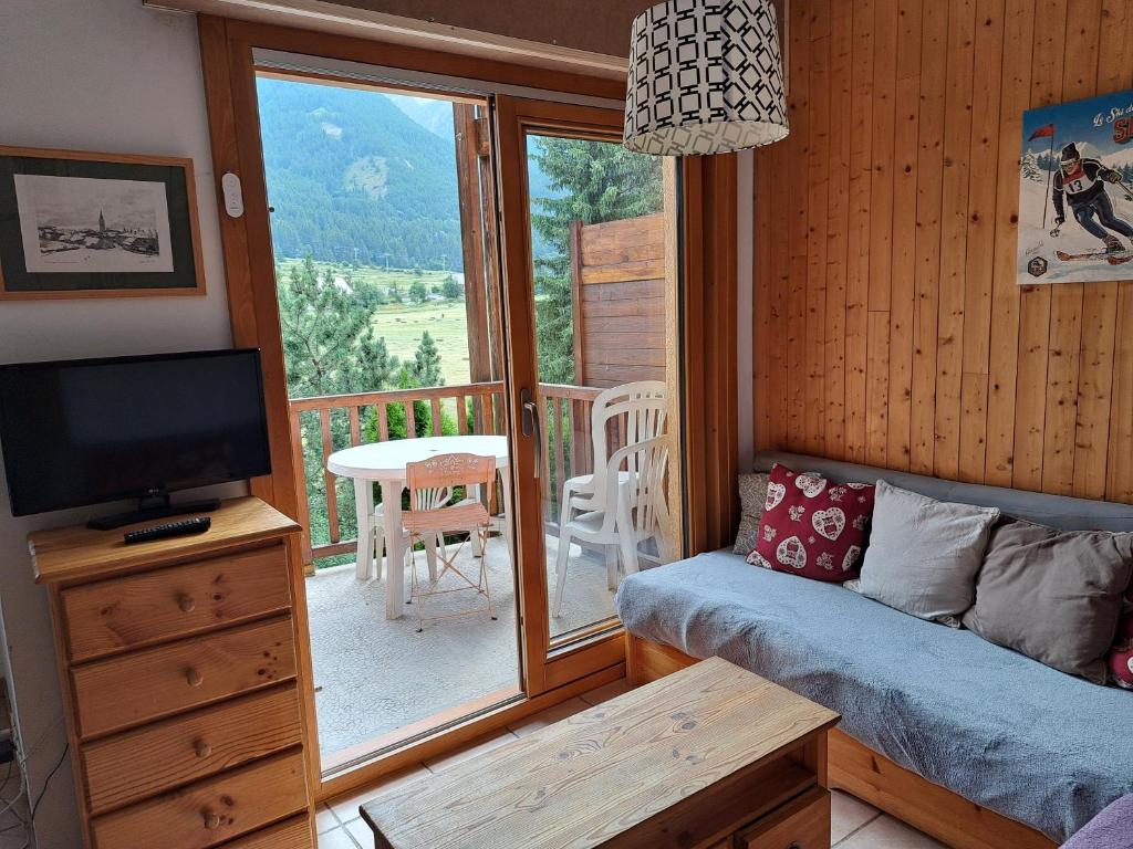 Il comprend un salon avec un canapé, une télévision et un balcon. dans l'établissement Marmotte Le Monêtier Apartment, au Monêtier-les-Bains 29 autres photos