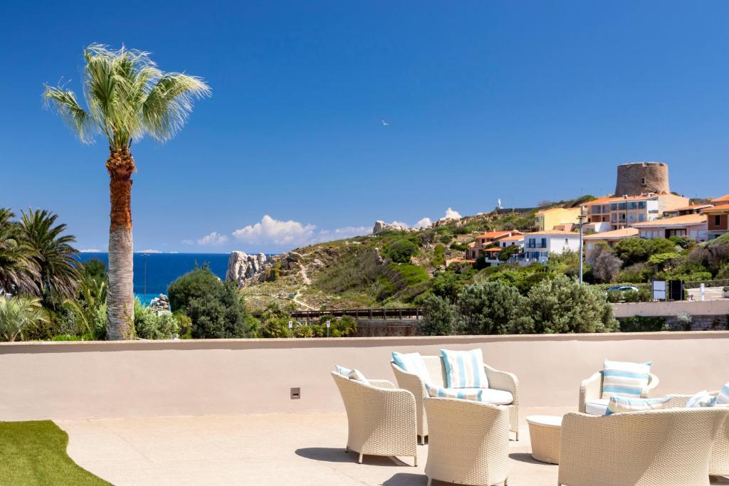 un patio avec des chaises et une vue sur l'océan dans l'établissement Hotel Corallaro, à Santa Teresa Gallura